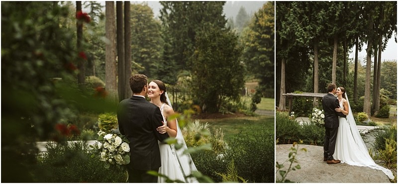 A bride and groom stand outdoors in a lush snohomish garden holding each other and smiling Tall trees and greenery surround them creating a romantic natural backdrop for their wedding portraits Snohomish wedding photography