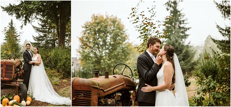 A bride and groom in wedding attire embrace and smile beside an old rusted tractor in snohomish surrounded by greenery and pumpkins with tall trees and autumn foliage in the background Snohomish wedding photography