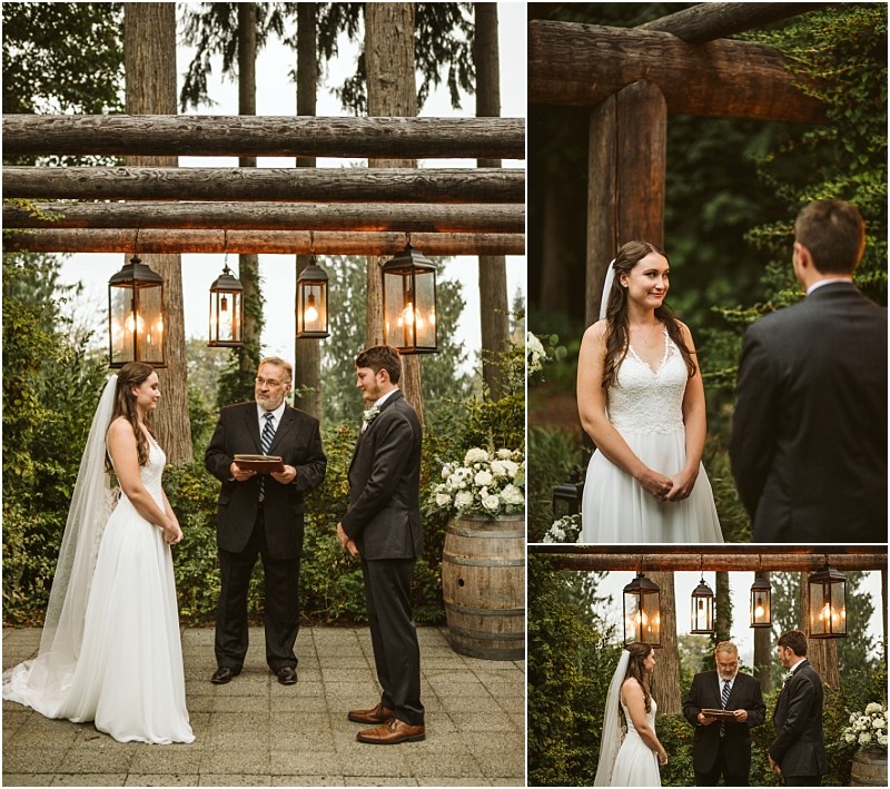 A bride and groom stand facing each other during an outdoor snohomish wedding ceremony with an officiant reading from a book under rustic wooden beams and hanging lanterns surrounded by lush greenery Snohomish wedding photography