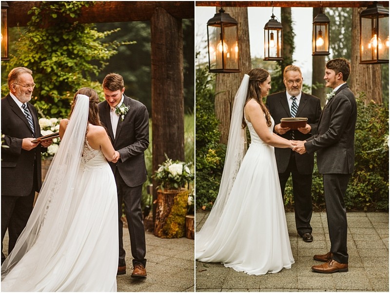 A bride in a white dress and veil holds hands with a groom in a dark suit during an outdoor snohomish wedding ceremony standing before an officiant under rustic lanterns and lush greenery Snohomish wedding photography