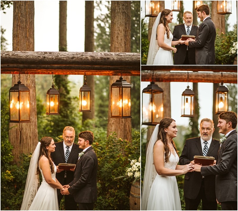 A bride and groom stand under rustic hanging lights and wooden beams during an outdoor snohomish forest wedding ceremony holding hands and exchanging vows in front of an officiant Snohomish wedding photography