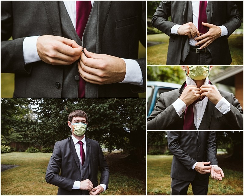 A man in a dark suit and maroon tie buttons his jacket and adjusts his cuffs in various close up shots In one image he stands outside in snohomish wearing a green face mask The background shows grass and trees Snohomish wedding photography