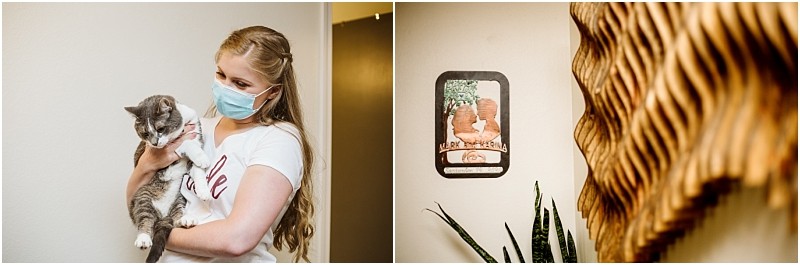 A woman wearing a mask holds a gray and white cat indoors in snohomish On the wall beside her is a wooden plaque with an image of a cat and greenery and a plant is visible below the plaque Snohomish wedding photography