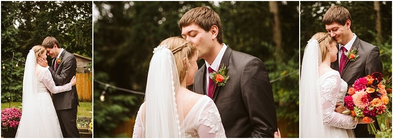 A bride and groom share an intimate outdoor moment in snohomish embracing and smiling at each other The bride holds a colorful bouquet as the groom kisses her forehead with trees and soft lights glowing in the background Snohomish wedding photography