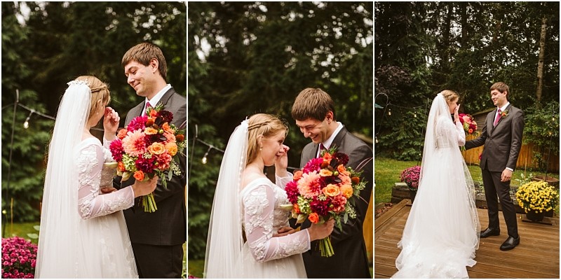 A bride and groom stand outdoors in snohomish smiling and gazing at each other The bride holds a colorful bouquet and wears a white dress and veil the groom is in a suit Trees and flowers are visible in the background Snohomish wedding photography