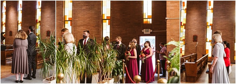 A group of people dressed formally including several women in burgundy dresses stand in a snohomish church with stained glass windows and brick walls Some hold bouquets and a few are wearing face masks Snohomish wedding photography