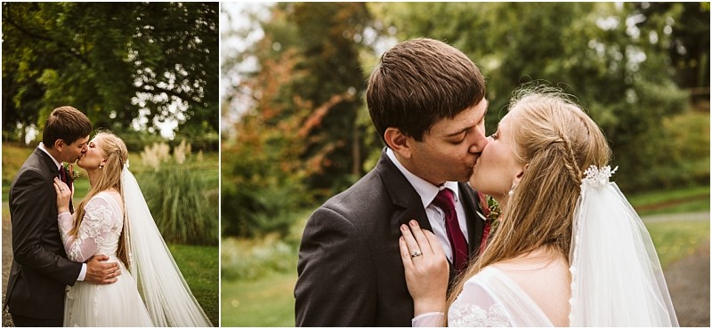 A bride and groom share a kiss outdoors in snohomish surrounded by lush greenery The bride wears a white dress with lace sleeves and a veil while the groom is in a dark suit and tie Snohomish wedding photography