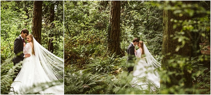 A bride and groom embrace in a lush green snohomish forest The brides long veil flows behind her as they stand surrounded by tall trees and ferns creating a romantic and serene atmosphere Snohomish wedding photography