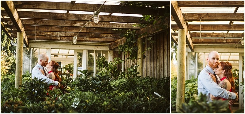 A couple embraces and smiles at each other while standing among lush green plants under a wooden pergola in a sunlit snohomish garden setting Snohomish wedding photography