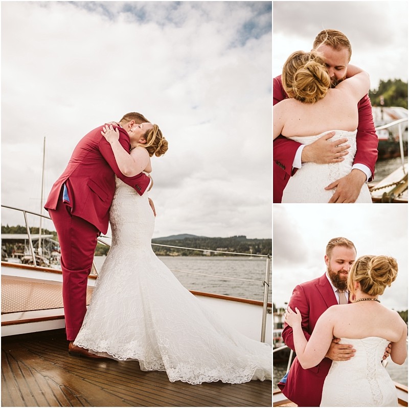 A bride and groom embrace on a boat deck in snohomish The groom wears a red suit the bride a white lace gown Set outdoors by the water boats and cloudy skies create a romantic snohomish backdrop Snohomish wedding photography