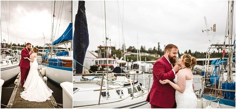 A bride in a white gown and a groom in a burgundy suit embrace on a snohomish dock surrounded by sailboats with overcast skies above Snohomish wedding photography