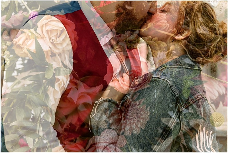 A romantic couple kisses in snohomish the man in a red vest and the woman in a denim jacket Their image is overlaid with soft pastel colored flowers creating a dreamy double exposure effect Snohomish wedding photography