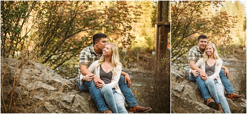 A man and woman sit on rocks outdoors in snohomish surrounded by autumn trees The man hugs the woman from behind kissing her head in one image Both are smiling and casually dressed in jeans enjoying the peaceful outdoor moment Snohomish wedding photography