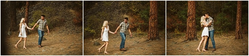 A couple in casual clothes walks hand in hand outdoors in snohomish then stops to embrace and kiss among trees and rocky terrain in a scenic natural setting Snohomish wedding photography