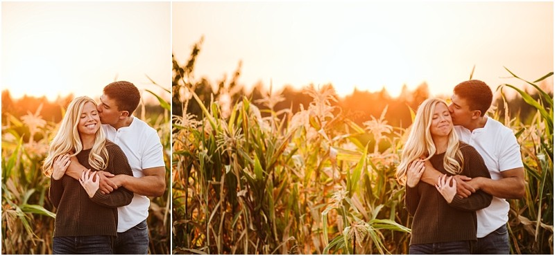 A couple stands in a snohomish cornfield at sunset The man hugs the woman from behind and kisses her on the cheek while she smiles with her eyes closed savoring their special moment together Snohomish wedding photography