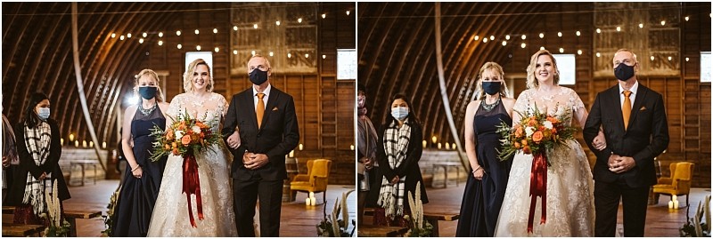 A bride in a white gown holds a bouquet and stands between two people all smiling Another woman and a man both masked stand nearby in a warmly lit rustic snohomish venue with string lights Snohomish wedding photography