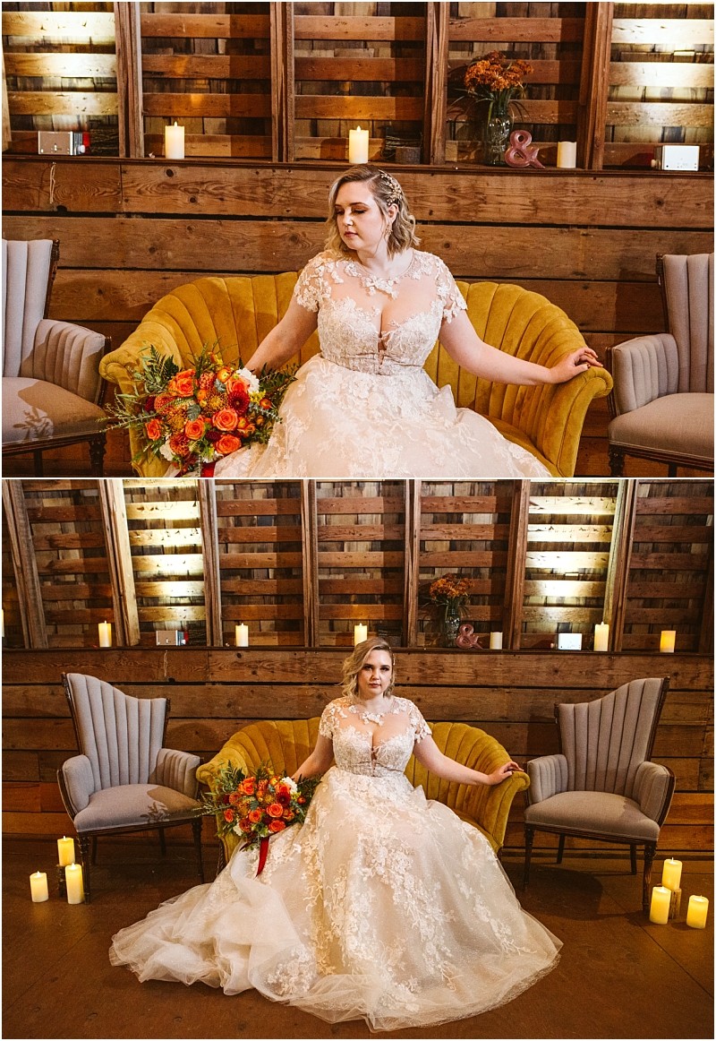 A bride in a lace wedding gown sits on a yellow vintage sofa holding a bouquet of orange and red flowers surrounded by candles and wooden decor in a rustic snohomish setting Snohomish wedding photography