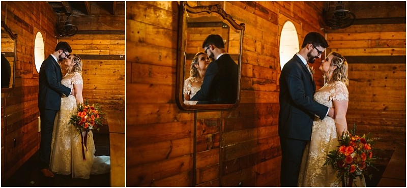 A bride and groom stand closely together in a warmly lit wooden room in snohomish The bride holds a vibrant bouquet as the couple lovingly gaze at each other their reflection visible in a wall mirror Snohomish wedding photography