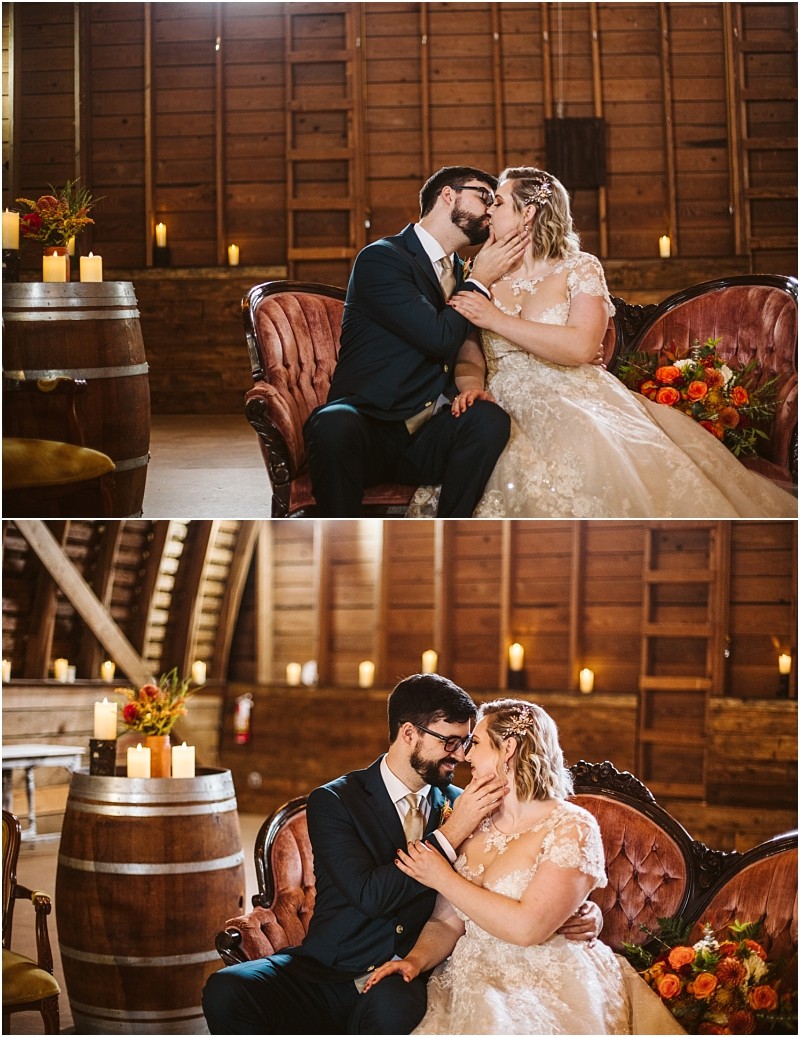A bride and groom sit closely on a vintage couch in a rustic snohomish barn smiling and touching faces lovingly Candles and orange flowers decorate the space creating a warm romantic atmosphere Snohomish wedding photography