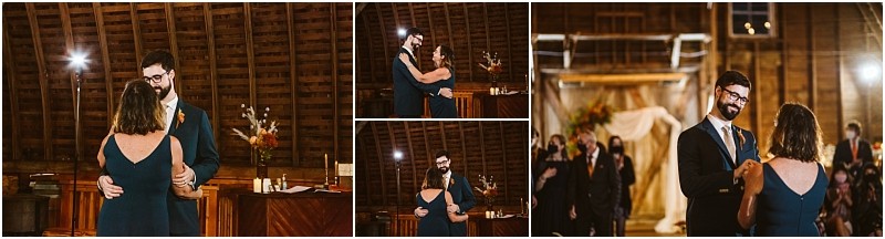 A man in a suit and a woman in a blue dress share a dance inside a rustic wooden snohomish barn during a formal event with warm lighting and people watching in the background Snohomish wedding photography