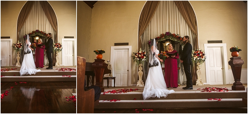 A bride and groom stand with an officiant on a snohomish church altar decorated with flowers and rose petals preparing to exchange vows The bride wears a white gown the groom wears a dark suit Snohomish wedding photography