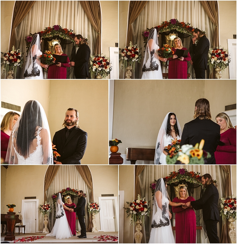 A couple stands before an officiant during a small indoor snohomish wedding ceremony exchanging vows and rings The room is decorated with flowers and the bride wears a veil and white dress while the groom is in black attire Snohomish wedding photography
