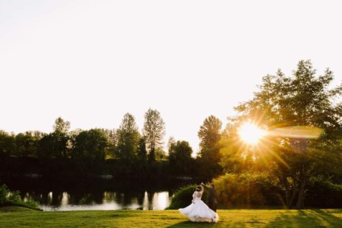 A couple in wedding attire dances on a grassy lawn near a river at sunset the sun casting a warm glowperfect inspiration for couples searching for scenic Washington wedding venues Snohomish Wedding Photography A couple in wedding attire dances on a grassy lawn near a river at sunset, the sun casting a warm glow—perfect inspiration for couples searching for scenic Washington wedding venues. Snohomish Wedding Photography