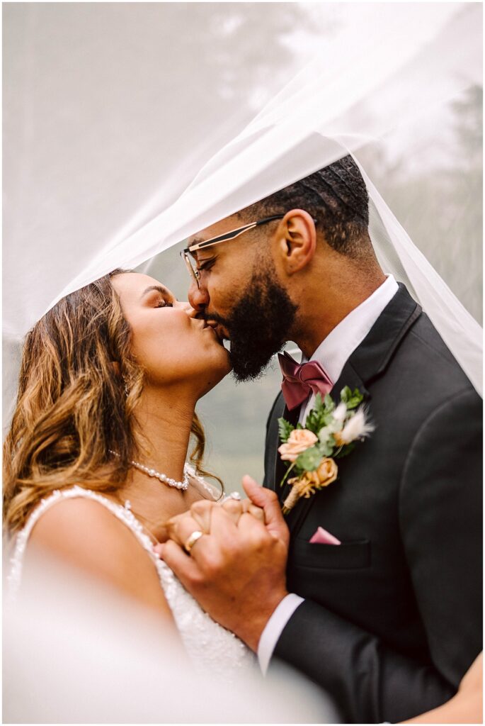 Gray bridge sultan wedding couple kissing under the veil