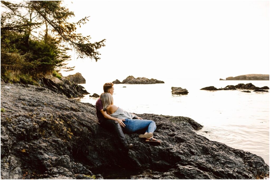 Oak harbor engagement session at rosario beach couple sitting on the rocks looking out at the water