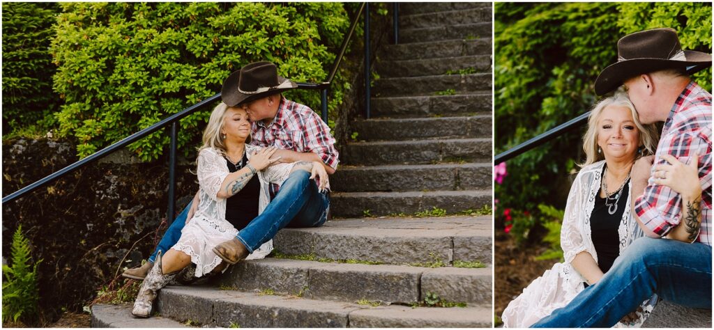Snohomish Wedding Photographer GSquared Weddings A couple in Western attire sits on stone steps outdoors. The woman, wearing a white lace cardigan and cowboy boots, leans against the man, who is in a plaid shirt and cowboy hat. Green foliage surrounds them on a sunny day. Serving Seattle, Snohomish and Washington State