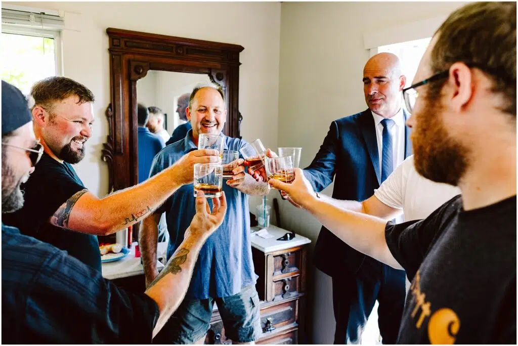 Snohomish Wedding Photographer GSquared Weddings A group of six men stand in a room raising glasses in a celebratory toast They are smiling and appear to be in a festive mood with a mirror and wooden furniture in the background Serving Seattle Snohomish and Washington State Snohomish Wedding Photographer GSquared Weddings A group of six men stand in a room, raising glasses in a celebratory toast. They are smiling and appear to be in a festive mood, with a mirror and wooden furniture in the background. Serving Seattle, Snohomish and Washington State