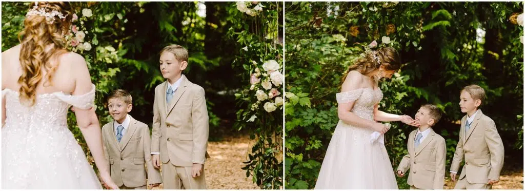 Snohomish Wedding Photographer GSquared Weddings A bride in an offshoulder gown stands with two young boys in beige suits in a lush green outdoor setting They are under an arch adorned with flowers as the bride interacts with the boys who look up at her Serving Seattle Snohomish and Washington State Snohomish Wedding Photographer GSquared Weddings A bride in an off-shoulder gown stands with two young boys in beige suits in a lush, green outdoor setting. They are under an arch adorned with flowers, as the bride interacts with the boys who look up at her. Serving Seattle, Snohomish and Washington State