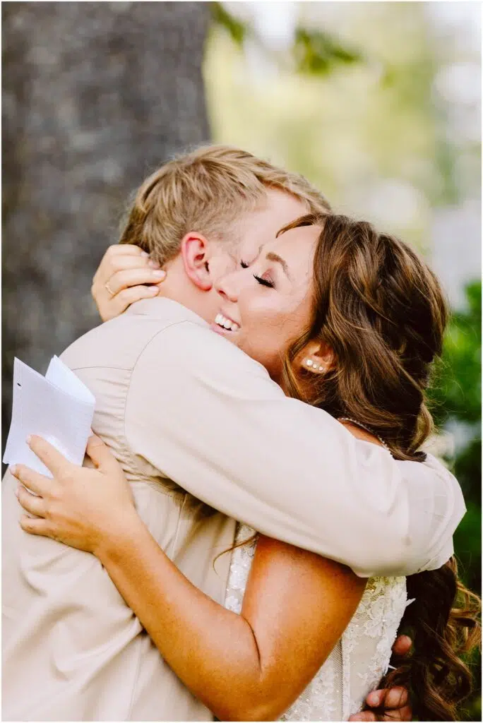 Snohomish Wedding Photographer GSquared Weddings A couple embraces outdoors both smiling joyfully The woman holds a piece of paper and they are both dressed in lightcolored formal attire Greenery and a tree trunk are visible in the background suggesting a natural setting Serving Seattle Snohomish and Washington State Snohomish Wedding Photographer GSquared Weddings A couple embraces outdoors, both smiling joyfully. The woman holds a piece of paper, and they are both dressed in light-colored, formal attire. Greenery and a tree trunk are visible in the background, suggesting a natural setting. Serving Seattle, Snohomish and Washington State
