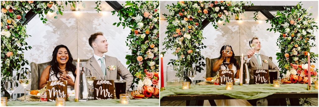 Snohomish wedding photographer gsquared weddings a happy couple sits at a decorated wedding table adorned with candles and flowers The woman laughs joyfully while the man sits beside her in front of a greenery arch with orange and pink flowers Signs reading mr Are placed on the table Serving seattle snohomish and washington state