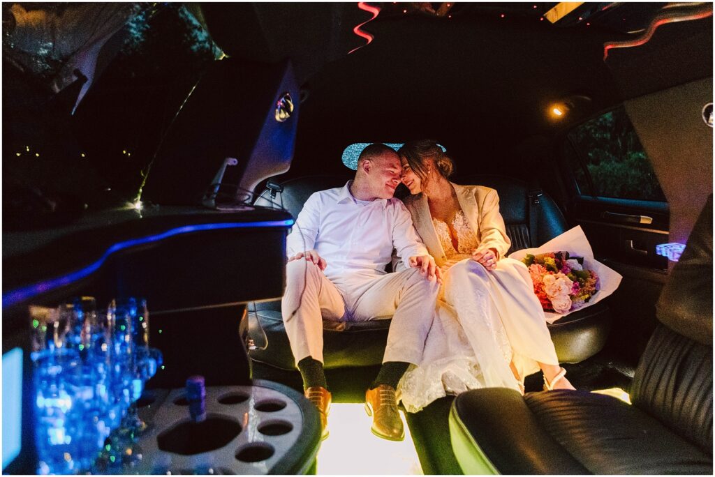 Snohomish wedding photographer gsquared weddings a couple in wedding attire sits closely together inside a decorated limo The bride holds a bouquet and soft interior lighting creates a romantic ambiance Glassware and decorative lights are visible around them Serving seattle snohomish and washington state