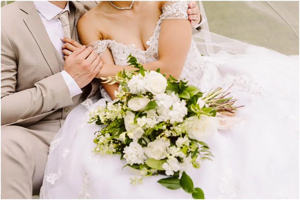 Snohomish Wedding Photographer GSquared Weddings A bride in a detailed white gown and a groom in a beige suit sit closely The bride holds a bouquet of white and green flowers Their heads arent visible in the frame Serving Seattle Snohomish and Washington State Snohomish Wedding Photographer GSquared Weddings A bride in a detailed white gown and a groom in a beige suit sit closely. The bride holds a bouquet of white and green flowers. Their heads arent visible in the frame. Serving Seattle, Snohomish and Washington State