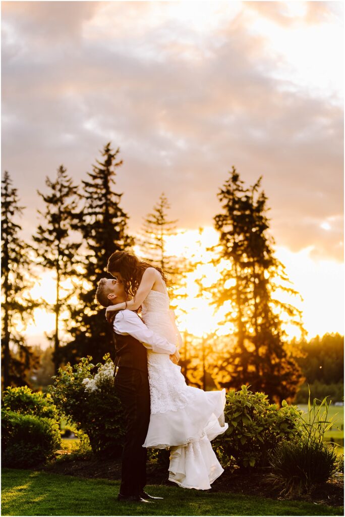 Snohomish wedding photographer gsquared weddings a couple is embracing outdoors at sunset with the man lifting the woman They are surrounded by greenery and tall trees are silhouetted against the vibrant sky The woman is wearing a white dress and the man is in a vest and trousers Serving seattle snohomish and washington state Snohomish wedding photographer gsquared weddings a couple is embracing outdoors at sunset with the man lifting the woman They are surrounded by greenery and tall trees are silhouetted against the vibrant sky The woman is wearing a white dress and the man is in a vest and trousers Serving seattle snohomish and washington state