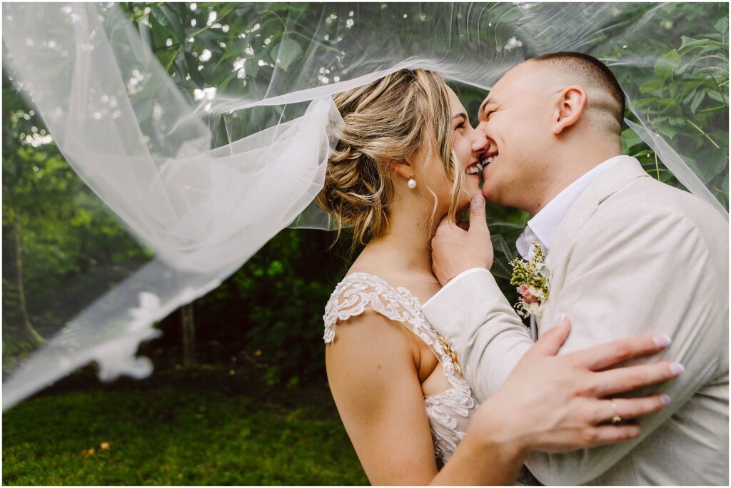 Snohomish wedding photographer gsquared weddings a bride and groom share a joyful moment under a veil The bride is gently touching the grooms face and both are smiling standing closely together The background is lush with greenery Serving seattle snohomish and washington state Snohomish wedding photographer gsquared weddings a bride and groom share a joyful moment under a veil The bride is gently touching the grooms face and both are smiling standing closely together The background is lush with greenery Serving seattle snohomish and washington state
