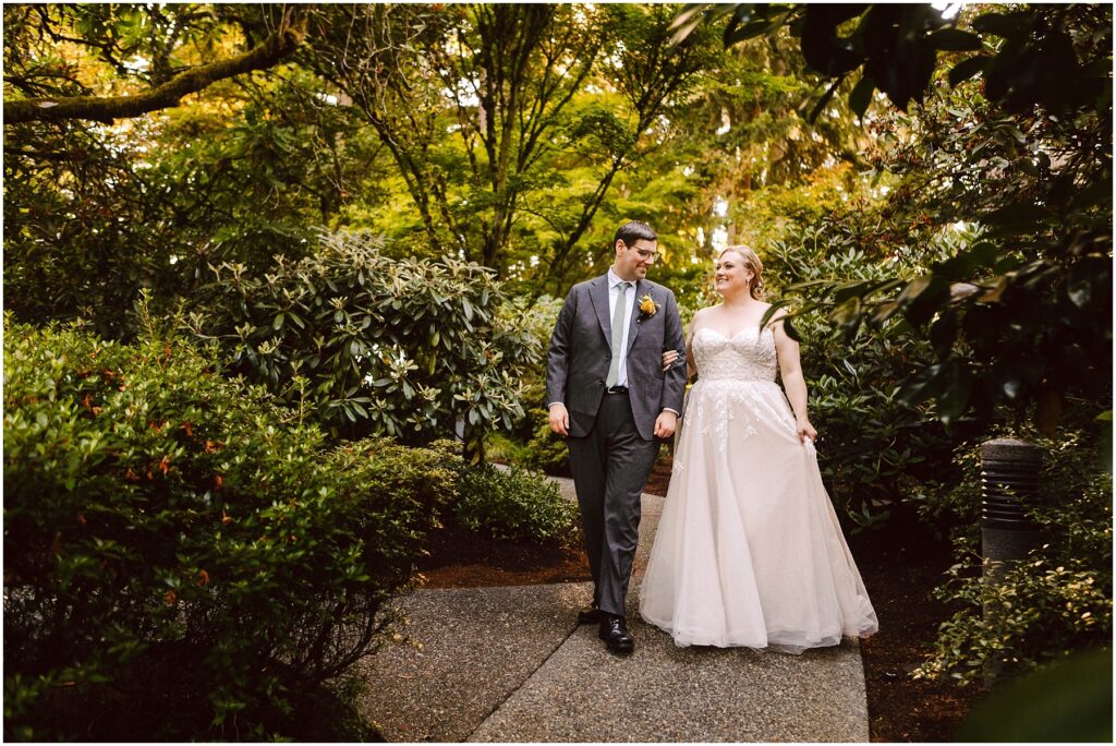 Snohomish wedding photographer gsquared weddings a bride and groom walk arm in arm down a garden path The bride is wearing a white dress and the groom is in a suit with a yellow boutonniere They are surrounded by lush green foliage and appear to be smiling Serving seattle snohomish and washington state Snohomish wedding photographer gsquared weddings a bride and groom walk arm in arm down a garden path The bride is wearing a white dress and the groom is in a suit with a yellow boutonniere They are surrounded by lush green foliage and appear to be smiling Serving seattle snohomish and washington state