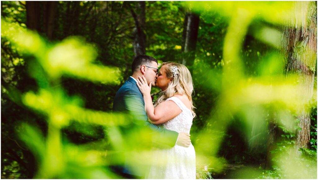 Snohomish wedding photographer gsquared weddings a couple is kissing in a lush green forest The bride is wearing a white dress and the groom is in a suit The scene is partially framed by out-of-focus greenery creating a vibrant and intimate atmosphere Serving seattle snohomish and washington state Snohomish wedding photographer gsquared weddings a couple is kissing in a lush green forest The bride is wearing a white dress and the groom is in a suit The scene is partially framed by out of focus greenery creating a vibrant and intimate atmosphere Serving seattle snohomish and washington state