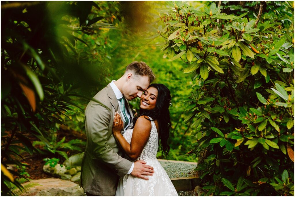 Snohomish wedding photographer gsquared weddings a couple embraces in a lush green garden The man in a gray suit gently leans his forehead against the woman who smiles while wearing a white lace dress They are surrounded by vibrant foliage creating a serene romantic atmosphere Serving seattle snohomish and washington state Snohomish wedding photographer gsquared weddings a couple embraces in a lush green garden The man in a gray suit gently leans his forehead against the woman who smiles while wearing a white lace dress They are surrounded by vibrant foliage creating a serene romantic atmosphere Serving seattle snohomish and washington state