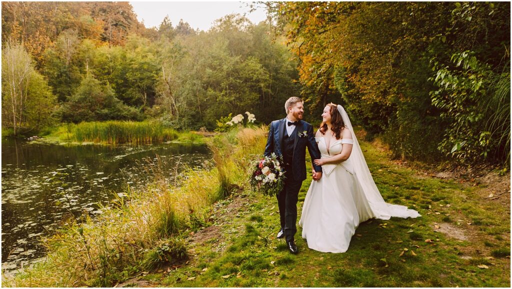 Snohomish wedding photographer gsquared weddings a bride and groom stroll hand in hand along a grassy path next to a pond The bride wears a white dress and holds a bouquet while the groom is in a suit Surrounding them are lush trees and vegetation The scene is serene and picturesque Serving seattle snohomish and washington state Snohomish wedding photographer gsquared weddings a bride and groom stroll hand in hand along a grassy path next to a pond The bride wears a white dress and holds a bouquet while the groom is in a suit Surrounding them are lush trees and vegetation The scene is serene and picturesque Serving seattle snohomish and washington state
