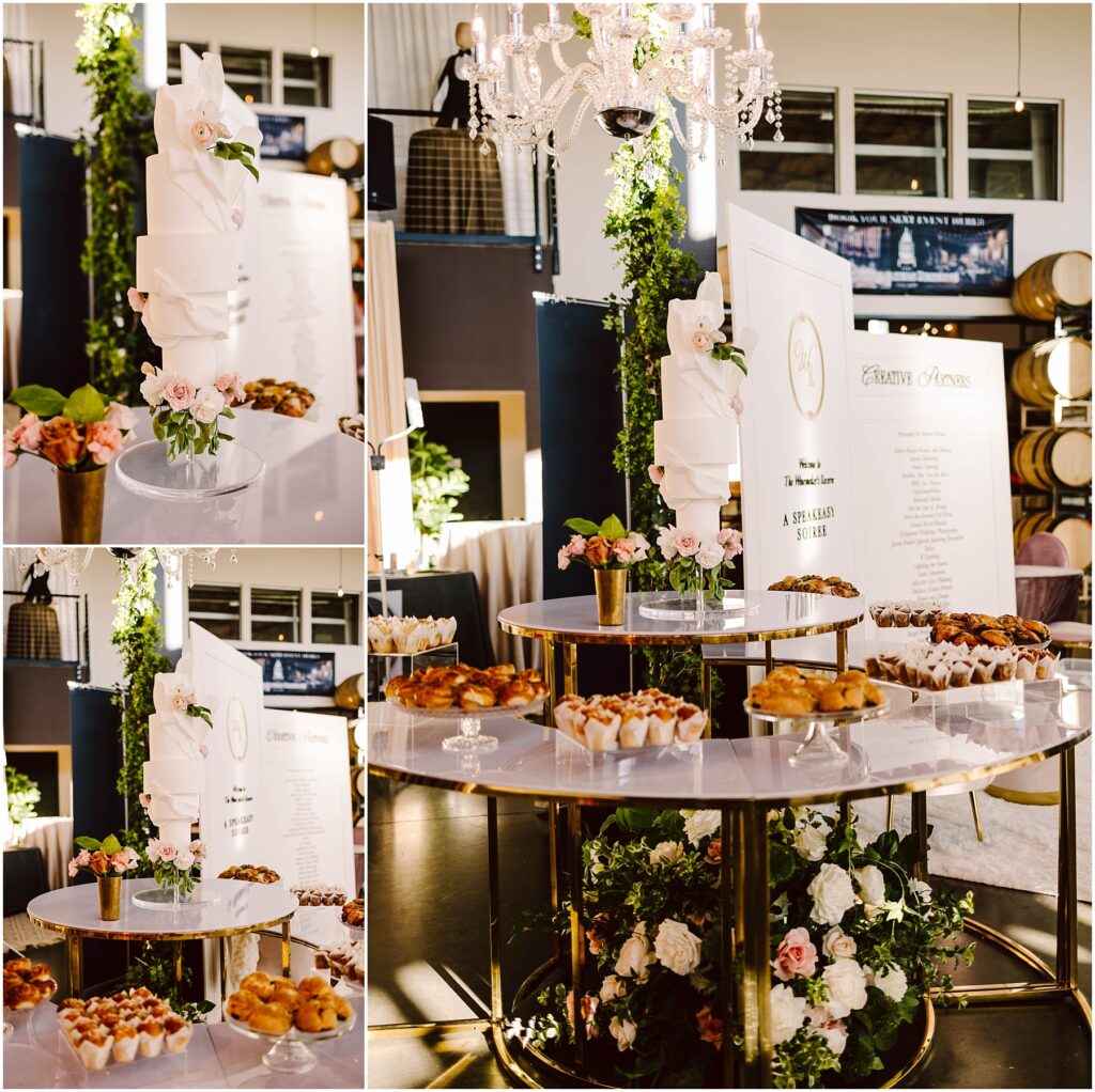 Snohomish Wedding Photographer GSquared Weddings A luxurious display features a tall white wedding cake adorned with white flowers. Surrounding it are trays of pastries on a tiered, gold-accented table. The backdrop includes greenery, chandeliers, and a sign with elegant script. Serving Seattle, Snohomish and Washington State