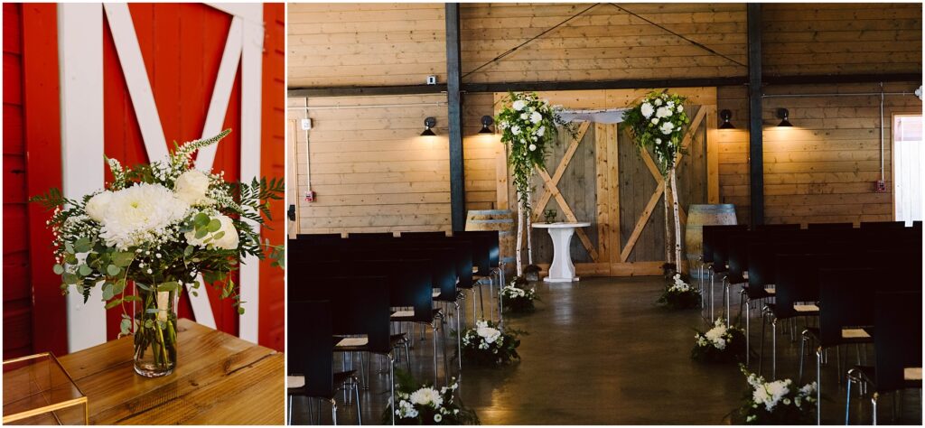 Snohomish Wedding Photographer GSquared Weddings A wooden barn interior set up for a wedding. The aisle is lined with floral arrangements, leading to an altar with a white table and lush greenery. On the left, a close-up of a vase with a white floral bouquet against a red barn door. Serving Seattle, Snohomish and Washington State