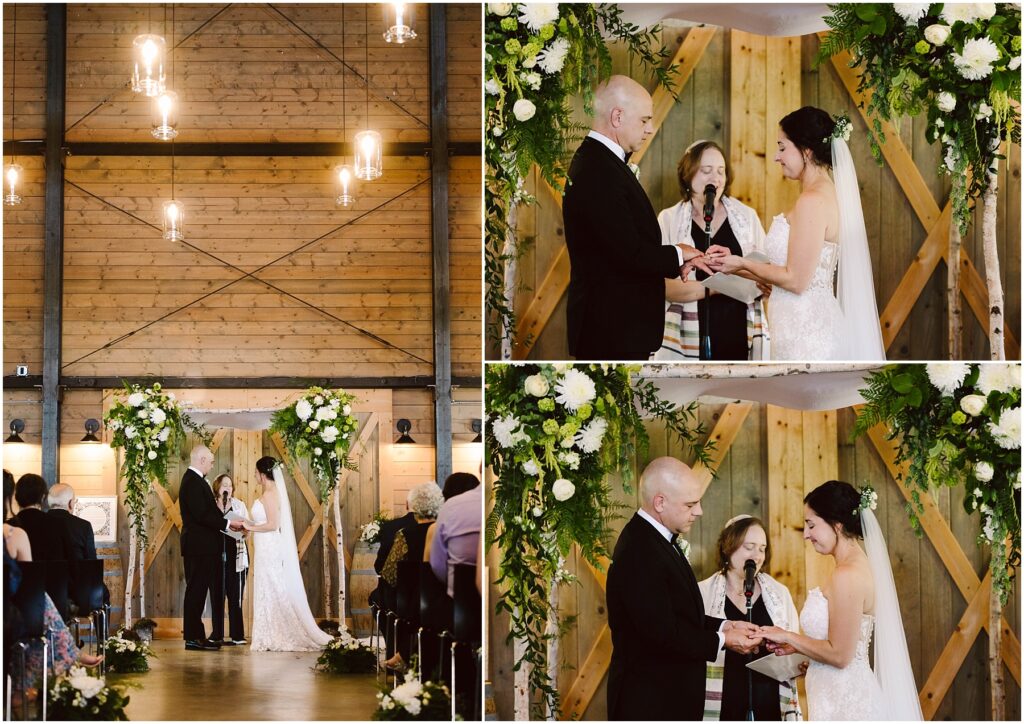Snohomish Wedding Photographer GSquared Weddings A wedding ceremony in a wooden venue. A couple stands facing each other under an arch adorned with greenery and white flowers. They exchange vows with an officiant between them. Guests are seated, watching the ceremony. Serving Seattle, Snohomish and Washington State