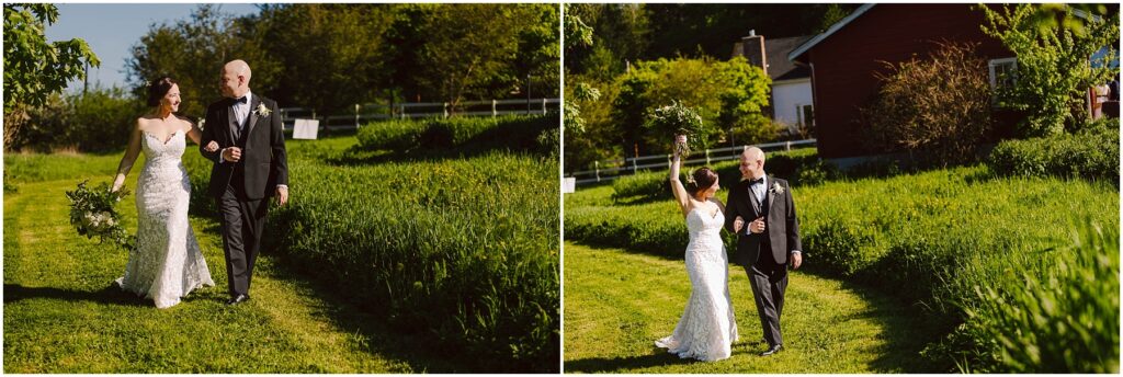 Snohomish Wedding Photographer GSquared Weddings A bride and groom walk joyfully through a grassy path on their wedding day. The bride holds a bouquet and wears a lace gown, while the groom is in a black suit. A rustic house and trees are visible in the background under a clear blue sky. Serving Seattle, Snohomish and Washington State