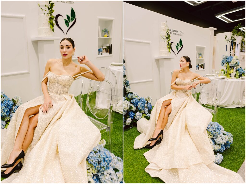 Snohomish Wedding Photographer GSquared Weddings A woman in an elegant cream gown with high slits poses gracefully on a transparent chair. The setting features white walls with floral arrangements and blue hydrangeas, creating a sophisticated ambiance. Serving Seattle, Snohomish and Washington State