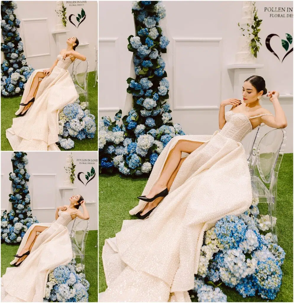 Snohomish Wedding Photographer GSquared Weddings A woman in a shimmering white gown with a high slit poses on a clear chair The background features blue hydrangeas and white flowers against a white wall with two hearts Grass covers the floor creating a fresh elegant scene Serving Seattle Snohomish and Washington State Snohomish Wedding Photographer GSquared Weddings A woman in a shimmering white gown with a high slit poses on a clear chair. The background features blue hydrangeas and white flowers against a white wall with two hearts. Grass covers the floor, creating a fresh, elegant scene. Serving Seattle, Snohomish and Washington State