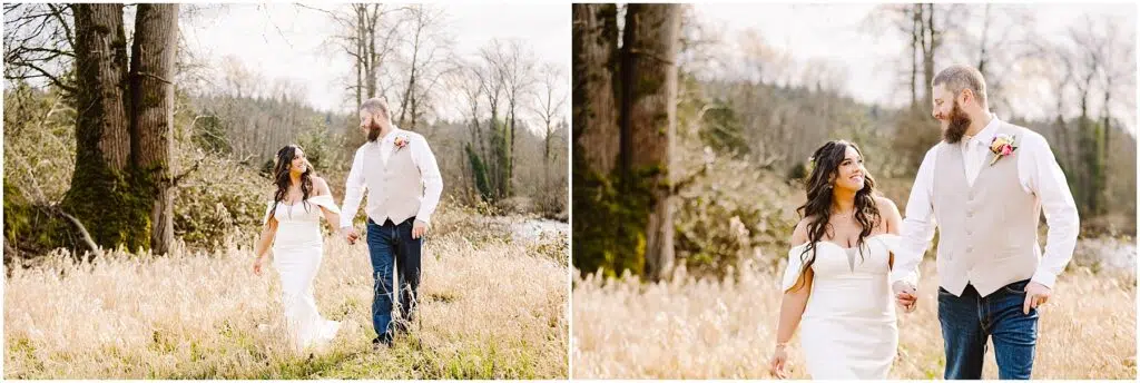 Snohomish Wedding Photographer GSquared Weddings A bride in a white dress and a groom in a light vest stroll hand in hand through a grassy field near Machias. With trees and a river as their backdrop, they smile at each other under the bright skies. Serving Seattle, Snohomish and Washington State
