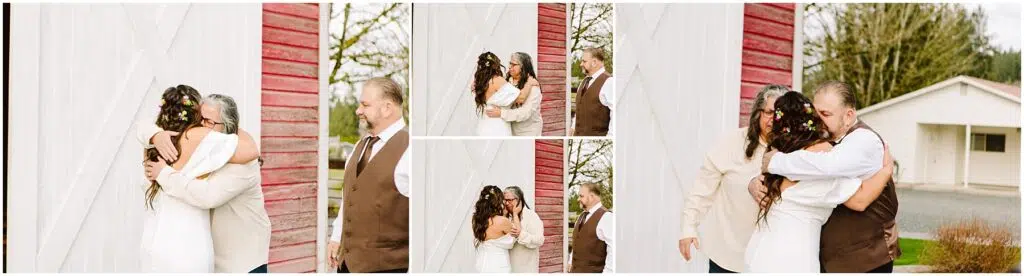 Snohomish Wedding Photographer GSquared Weddings A bride with floral hair adornments embraces two men in separate hugs, both wearing suits. They stand by a rustic red and white barn in Machias. A white house and trees are visible in the background under a cloudy sky. Serving Seattle, Snohomish and Washington State
